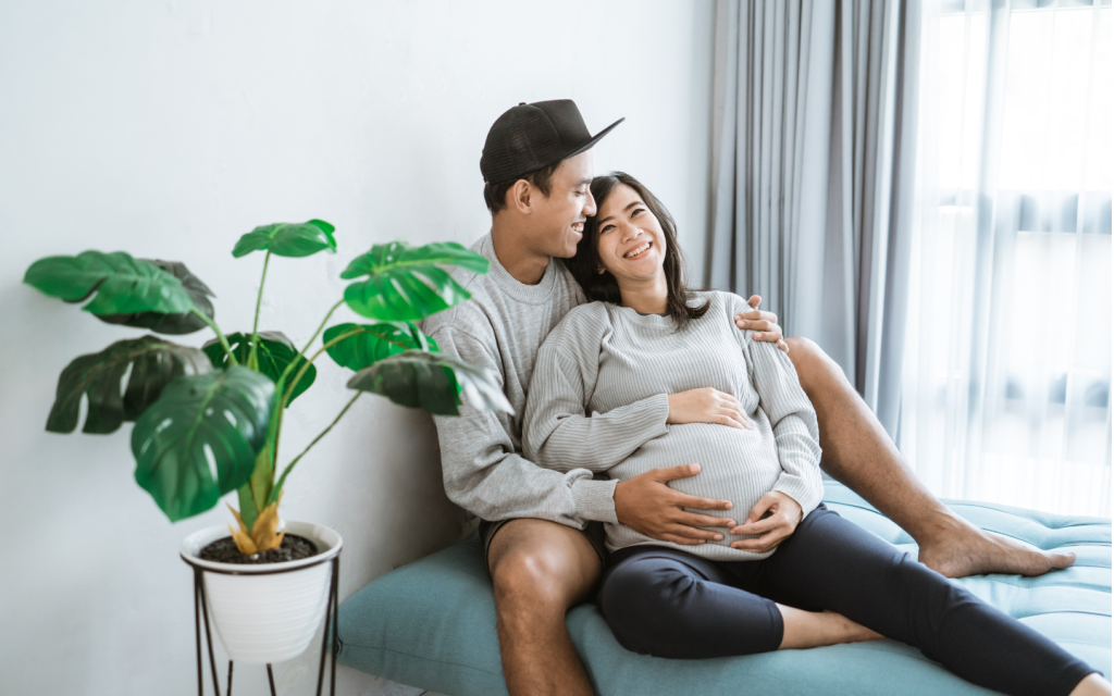 Pregnant couple relaxing on a couch together.