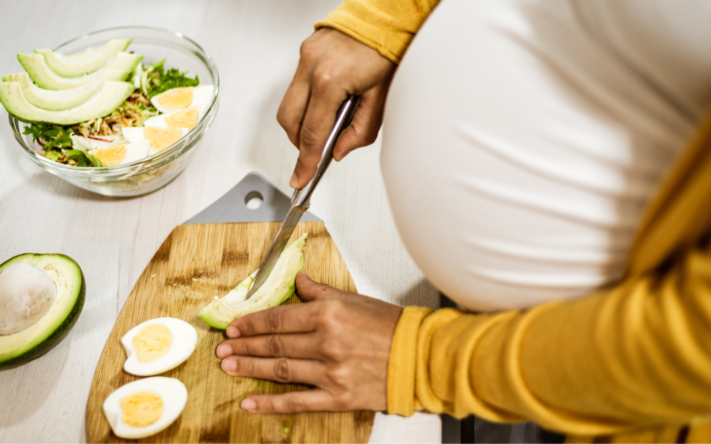 Pregnant person preparing a nutrient dense meal.